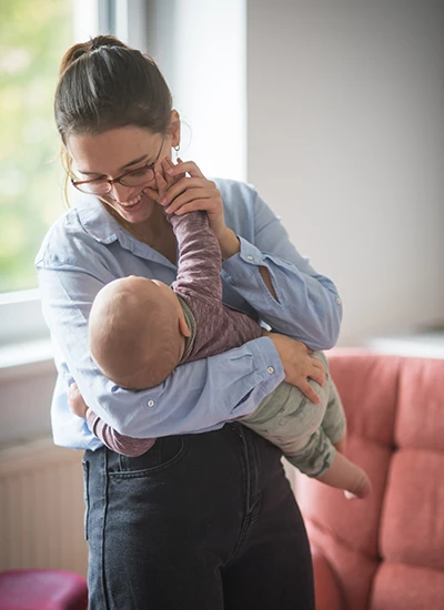 Hebamme trägt Baby auf dem Arm