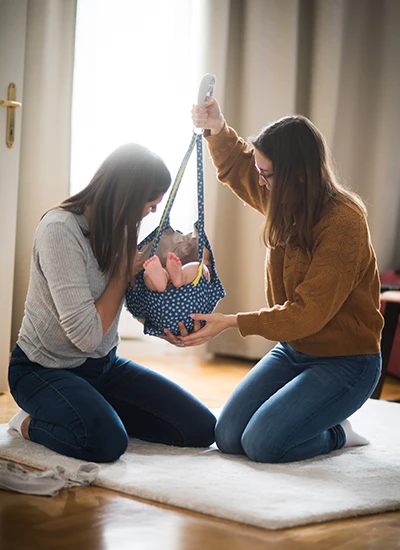 Baby wird in der Stoffwiege abgewogen